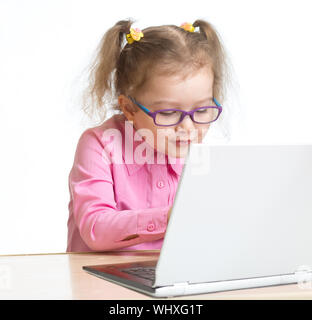 Happy kid in spectacles using notebook with great interest isolated on white Stock Photo