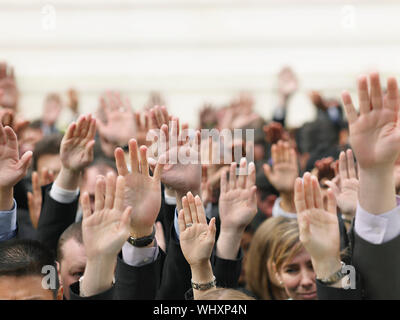 Closeup of business crowd raising hands Stock Photo