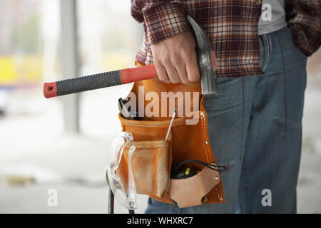 Closeup midsection of a male construction worker wearing tool belt Stock Photo