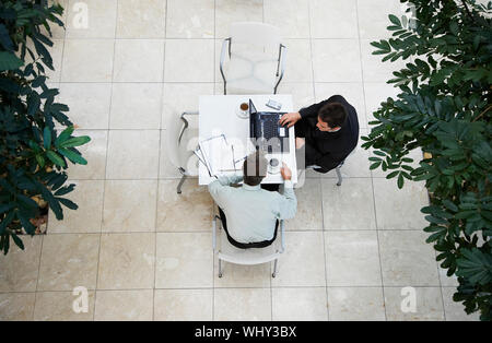 High angle view of businessmen having a discussion at office cafe Stock Photo