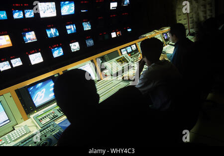 Rear view of operators in central control room at television station Stock Photo