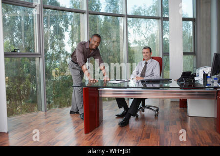 Portrait of a two multiethnic businessmen at desk in office Stock Photo