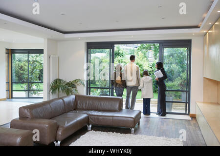 Rear view of parents with daughter and female estate agent at new property Stock Photo