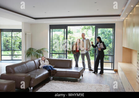 Parents with daughter and female estate agent observing new property Stock Photo