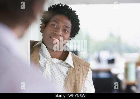 Closeup of an African American businessman talking to blurred colleague in office Stock Photo