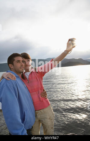 Young couple photographing themselves in the ocean Stock Photo