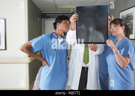 Group of doctors and nurses looking at X-ray in hospital Stock Photo