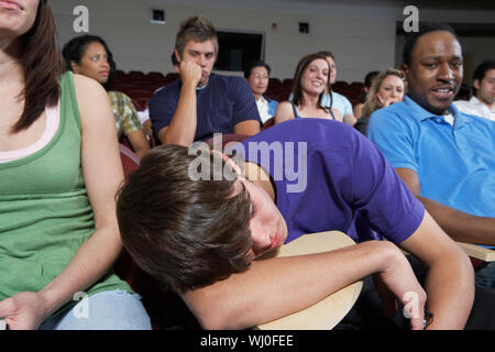 Bored students in lecture theatre during lesson Stock Photo