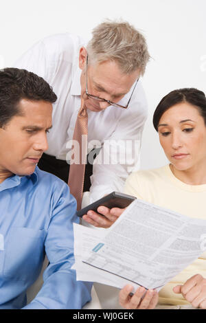 Couple with a financial planner discussing investment plans Stock Photo