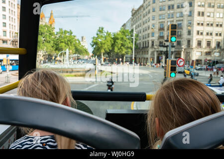 two children enjoying the sight on a hop on hop off bus in a big tourist city. Barcelona Spain Stock Photo