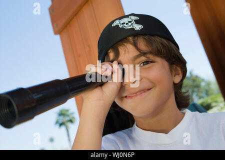 Portrait of a happy preadolescent boy looking through telescope Stock Photo