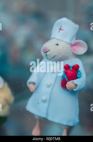 Small hand-made felt mouse in medical gown, doctor mouse, selective focus. Stock Photo