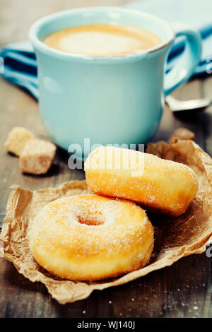 Coffee break with fresh sugary donuts over white background Stock Photo