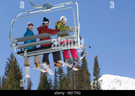 Three Skiers on Chair Lift Stock Photo