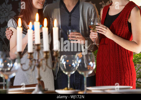Midsection of friends holding drinks by dining table Stock Photo
