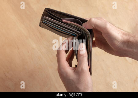 Man hold in his arm open purse with money. Finance success concept. Stock Photo