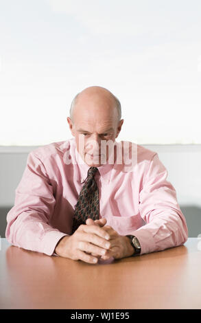 Portrait of a serious businessman sitting at office desk Stock Photo