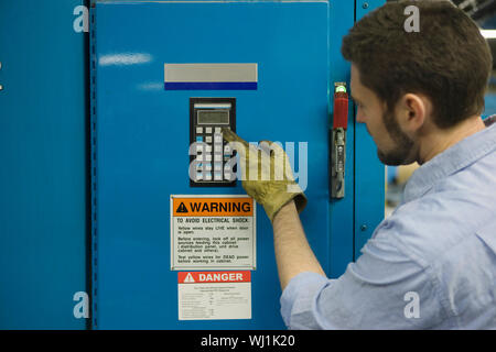 Closeup of a man pressing keypad in newspaper factory Stock Photo
