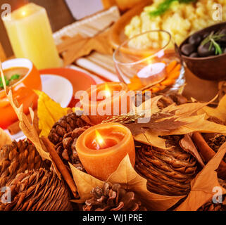 Closeup photo on beautiful autumnal still life for Thanksgiving day, pine cone and dry leaves decoration for festive dinner Stock Photo