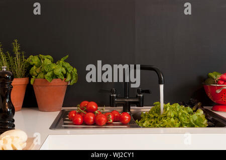 Washing vegetables in the kitchen sink Stock Photo