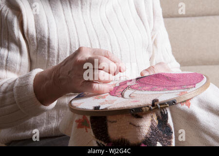Midsection of senior woman making embroider in hoop at home Stock Photo
