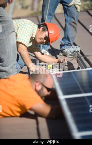Male engineers working on solar panel at rooftop Stock Photo