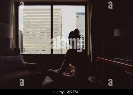 Rear View Of Woman Sitting In Hotel Room