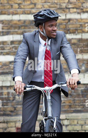 Portrait of African American businessman riding Bicycle Stock Photo