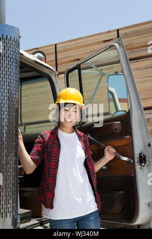 Portrait of an Asian female industrial worker standing by vehicle door Stock Photo