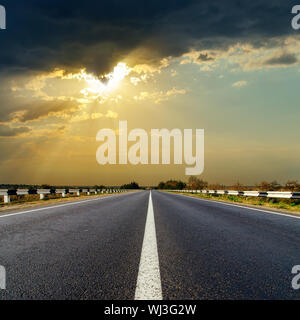 dark low clouds over asphalt road on sunset Stock Photo - Alamy