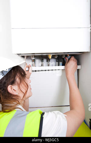 Female plumber servicing central heating boiler Stock Photo