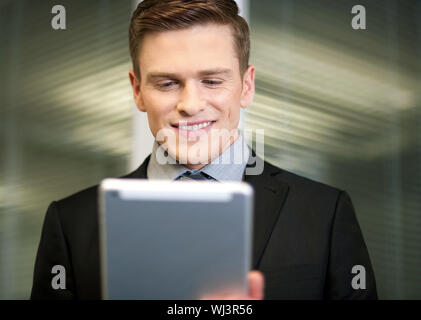 Corporate guy using tablet pc at workplace Stock Photo