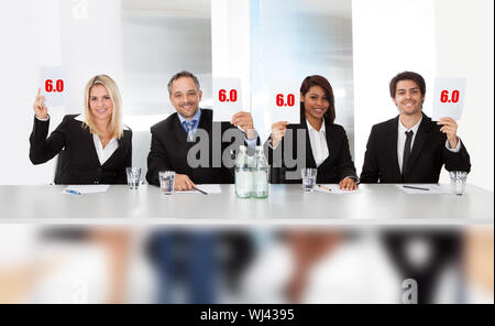 Group of panel judges holding perfect score signs Stock Photo