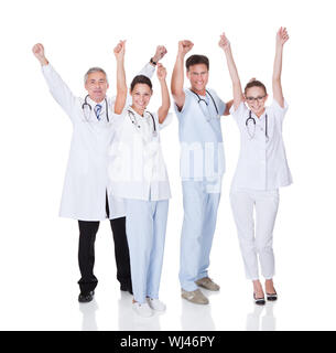 Diverse medical team of male and female doctors and nurses celebrating a successful outcome to a case Stock Photo