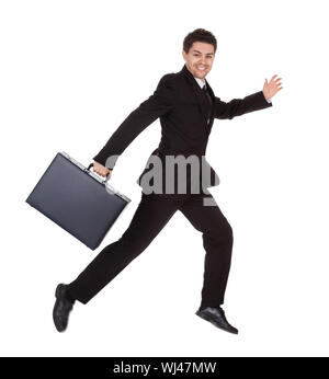 Successful businessman running with his briefcase hurrying along to an appointment full of energy isolated on white Stock Photo