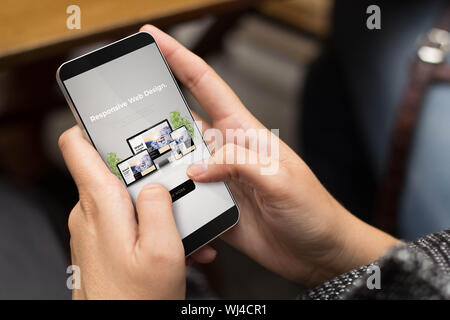 mobile design concept: girl using a digital generated phone with responsive devices website on the screen. All screen graphics are made up. Stock Photo
