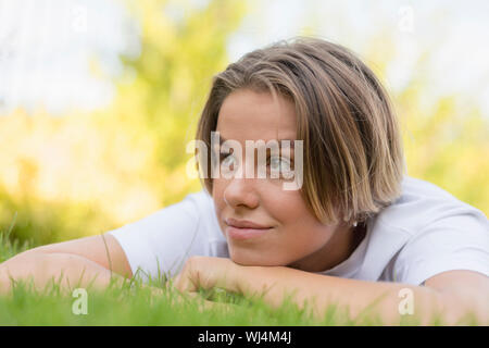 Young woman laying in grass Stock Photo