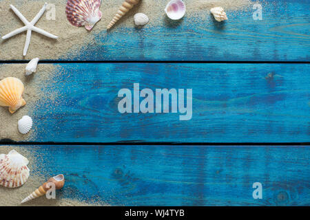 Summer banner with seashells, starfish and sand on blue wooden backround Stock Photo