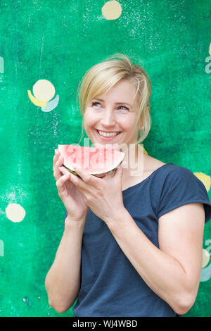 Portrait carefree, happy woman eating watermelon Stock Photo