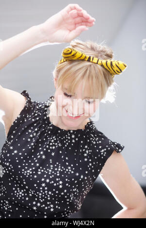 Playful woman in cat costume ears dancing Stock Photo