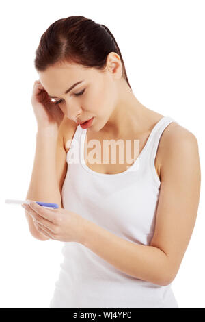 Sad, worried woman with pregnancy test. Isolated on white. Stock Photo