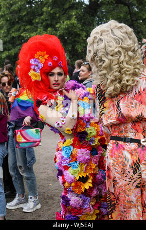 Drag queen with huge red wig posing for camera at Helsinki Pride after-party in Kaivopuisto Park Stock Photo