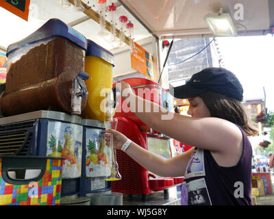 A young girl fills up her cup at a self service slushy machine Stock Photo