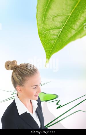 Composite image of blonde businesswoman looking away standing over green ecg line with heart Stock Photo