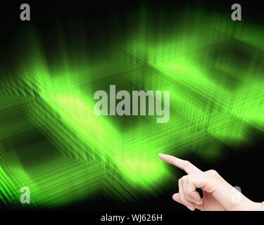 Composite image of businesswoman touching invisible screen on black and green glowing background Stock Photo