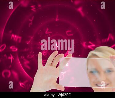 Composite image of blonde doctor holding virtual screen on pink background with swiveling letters Stock Photo