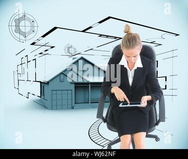 Composite image of businesswoman sitting on swivel chair with tablet in front of 3d house and plans Stock Photo