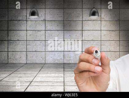 Composite image of businessman writing on camera with a marker pen in front of grey room Stock Photo