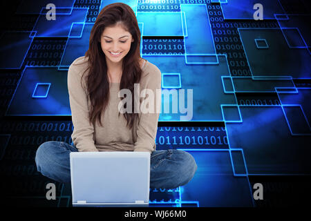 Composite image of beautiful smiling brunette sitting on floor using laptop Stock Photo