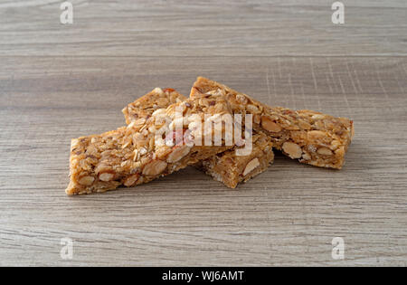 Side view of a group of three flax and almond seed granola bars on a countertop illuminated with natural light. Stock Photo